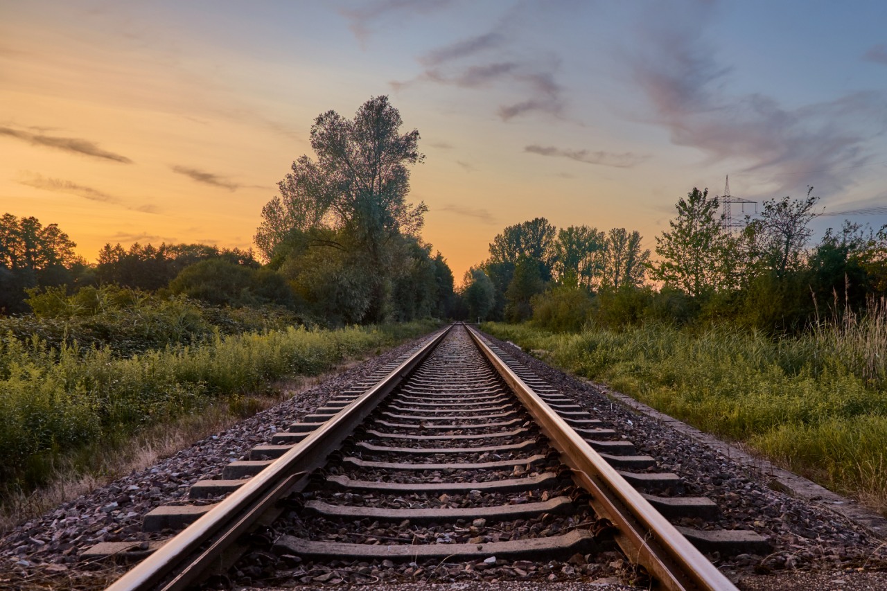Railway infront of grass fields, trees and sunset sky in Rastatt, Baden-WÃ¼rttemberg (Germany)